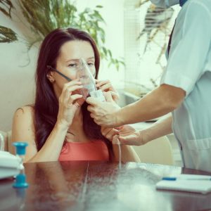 healthcare-professional-helps-woman-with-asthma-use-a-nebulizer